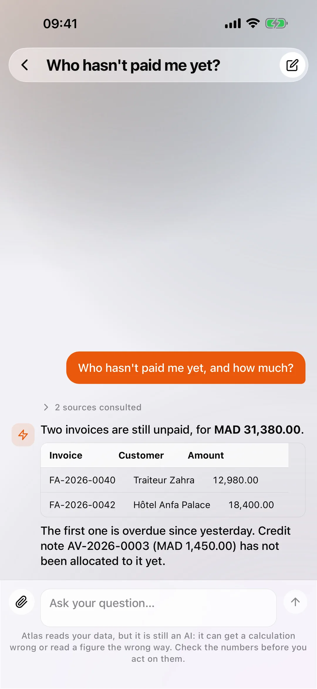 Atlas in the React Box mobile app, answering in plain language with a table of unpaid invoices.